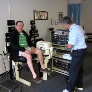 Mark Klunk, PTA, Physical Therapist Assistant at TheraSport Physical Therapy, guides a patient through exercises on the Biodex machine